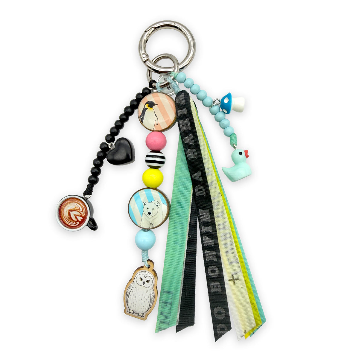 Taschenanhänger von Escapulario mit Eule, Eisbär, Pinguin, schwarzen und hellblauen Holzperlen, bunten Bonfim Glücksbändern und silberfarbenem Karabinerring.