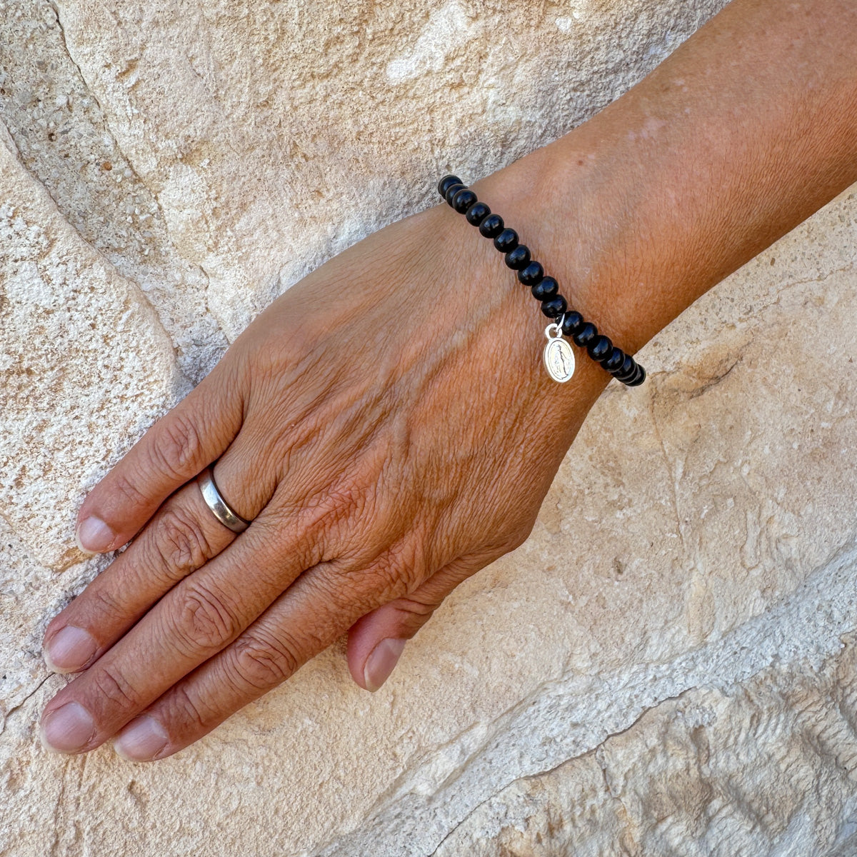 Escapulario Holzperlenarmband in Schwarz aus 6mm Holzperlen mit elastischem Band als schlichtes vielseitiges Armband für modebewusste Frauen.
