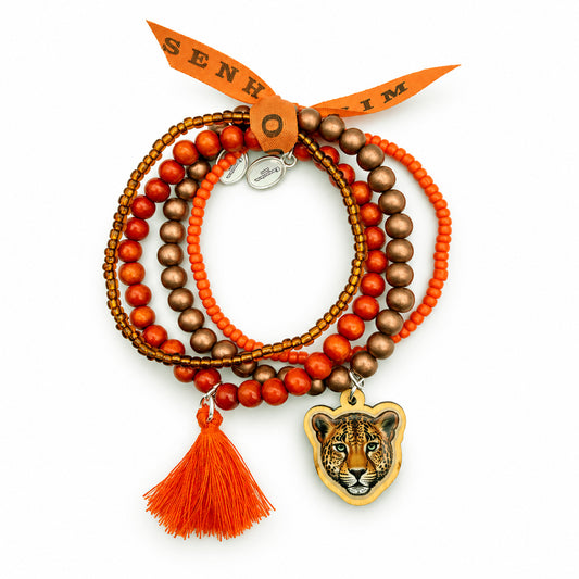 „Handgemachtes Escapulario Armbandset mit Holzperlen in Orange und Kupfer-Bronze, Leoparden-Anhänger, orangefarbener Quaste und Bonfimband auf weißem Hintergrund.“