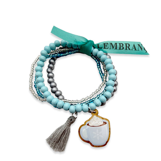 Escapulario Armbandset mit Holzpin Tasse mit heißer Schokolade, hellblauen Holzperlen, grauen und silberfarbenen Akzenten, Glasperlen und grauer Quaste.
