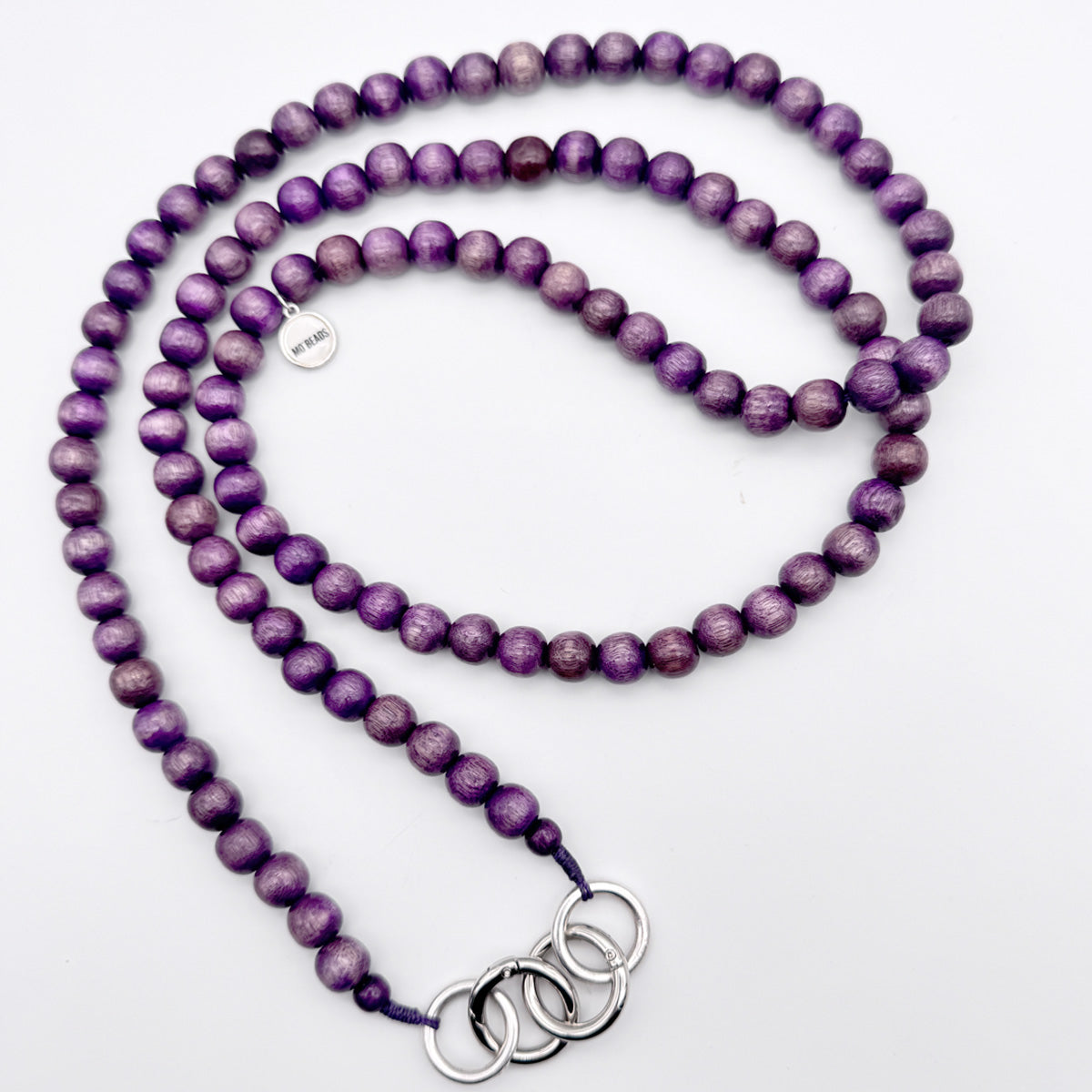 Escapulario Handykette in Lila mit Perlenkette und Metallkarabinern als farbintensives Smartphone-Accessoire für Frauen.