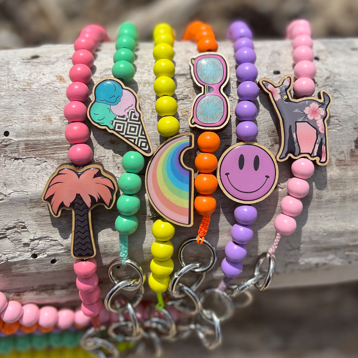 Escapulario Handykette in Pastellrosa mit Palmen-Holzpin, feinen Perlen und Karabinern als sommerliches Handyband für Damen.
