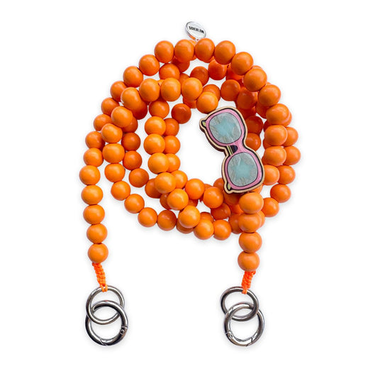 Escapulario Handykette in Neonorange mit Sonnenbrillen-Pin aus Holz und Metallkarabinern als auffälliges Smartphone-Accessoire für modebewusste Frauen.