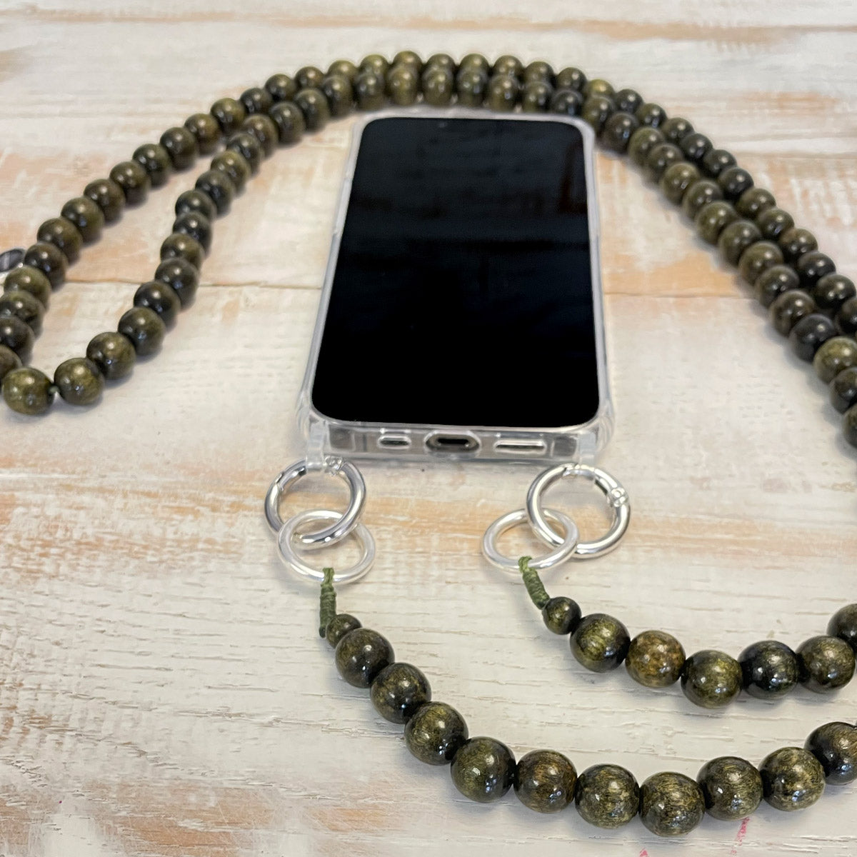 Escapulario Handykette in Olive mit matten Perlen und Karabinern als lässiges Handyband in Naturtönen.