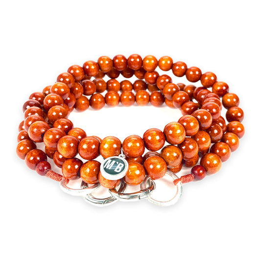 Escapulario Handykette in Terracotta mit warmen Perlen und Karabinern als trendiges Smartphone-Accessoire für Damen.