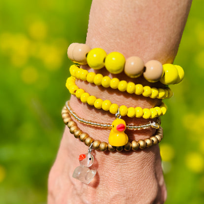 Escapulario Holzperlenarmband in Gelb Beige Mix aus 12mm Holzperlen mit elastischem Band als fröhlich buntes Sommer Accessoire für Frauen auf Blumenwiese mit Entenarmband.