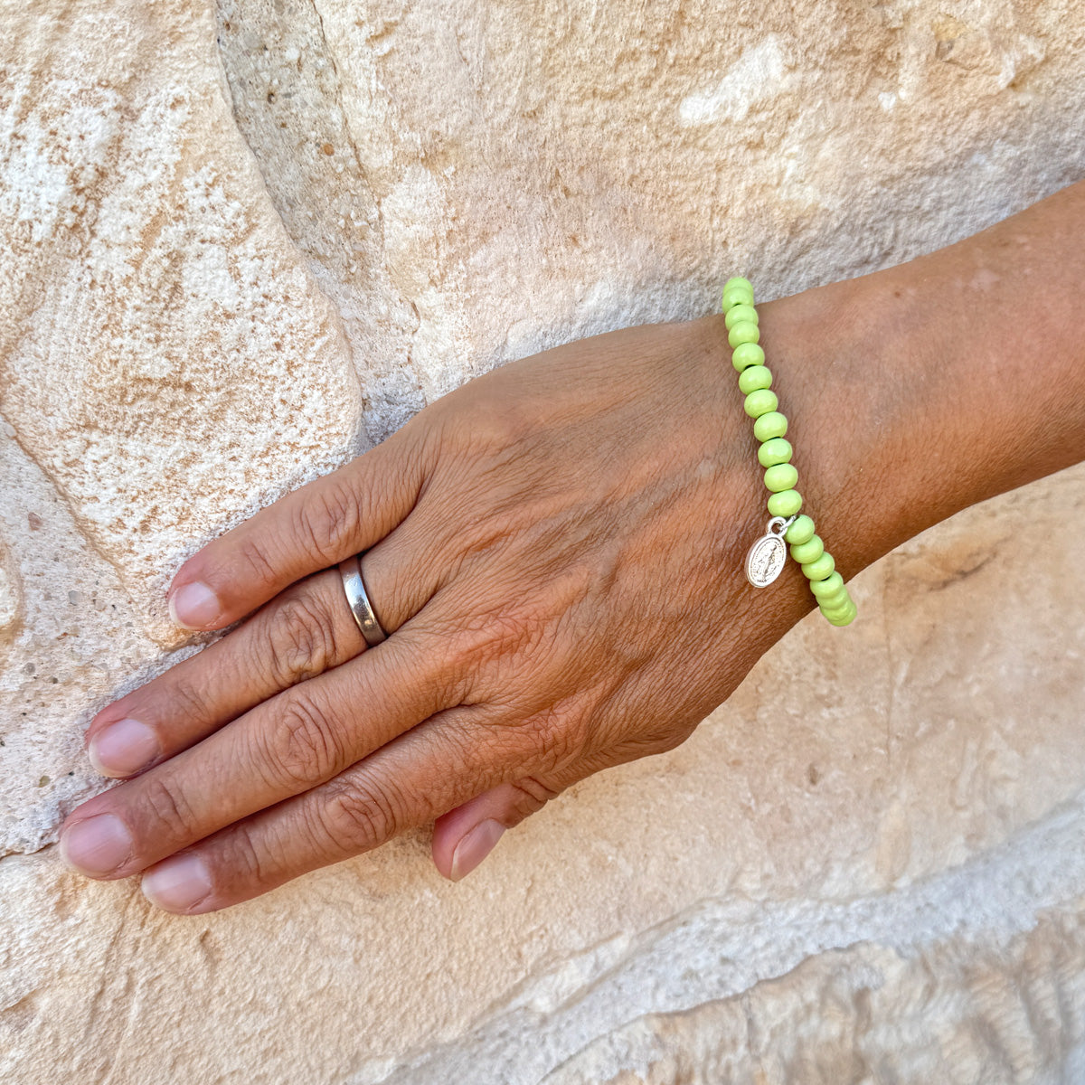 Escapulario Holzperlenarmband in Pistazie aus 6mm Holzperlen mit elastischem Band als frisch grünes sommerliches Accessoire für Frauen.