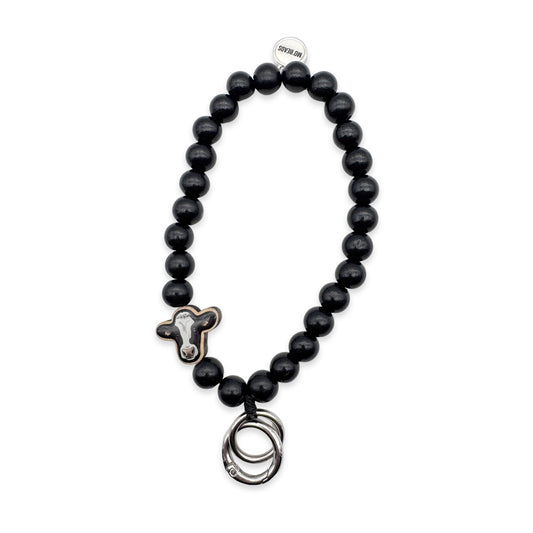 Escapulario Schlüsselkette in Schwarz mit Kuh-Holzpin aus Holzperlen als verspieltes Accessoire für Frauen, die ihre Schlüssel stilvoll tragen möchten.