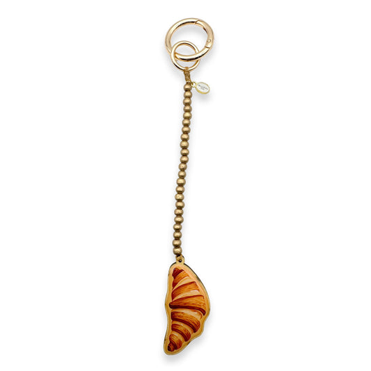 Escapulario Taschenanhänger Croissant als charmanter Paris inspirierter Bagcharm für Taschen und Handtaschen als süßes Accessoire für Damen.